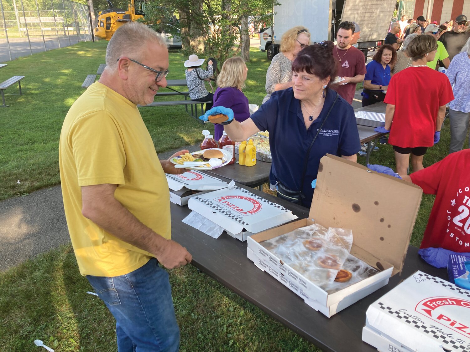 SERVING IT UP: Councilwoman Linda Folcarelli handles pizza chips from The Original Italian Bakery for hungry attendees.